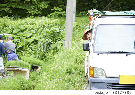 田植え 農作業 軽トラックを運転する女性の写真素材