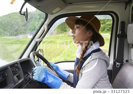 田植え 農作業 軽トラックを運転する女性の写真素材
