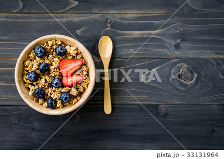 Homemade granola and fresh berries on wood table 33131964