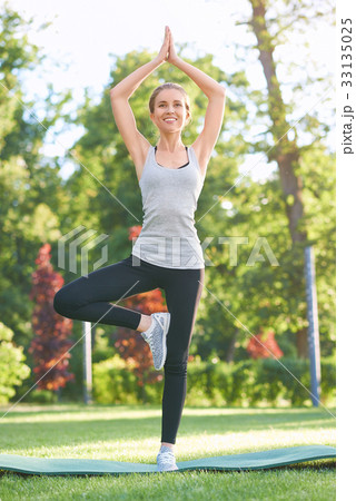 Young woman practicing yoga outdoors at the park 33135025