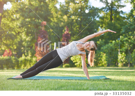 Young woman practicing yoga outdoors at the park 33135032