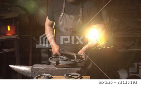 Man works with molten metal in the forge. Man works with molten metal in the forge. 33135193