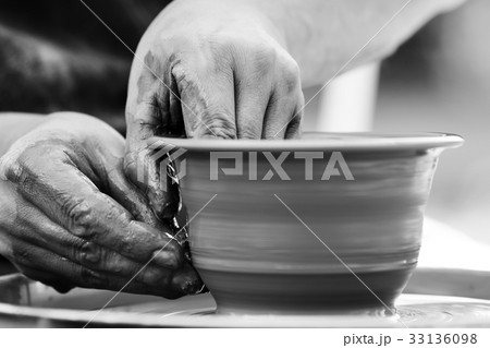 Potter making ceramic pot on the pottery wheel 33136098