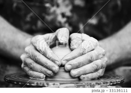 Potter making ceramic pot on the pottery wheel 33136111