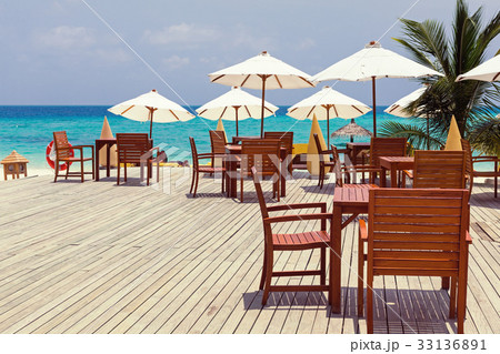 Wooden furniture with tables and chairs on terrace Wooden furniture with tables and chairs on terrace 33136891