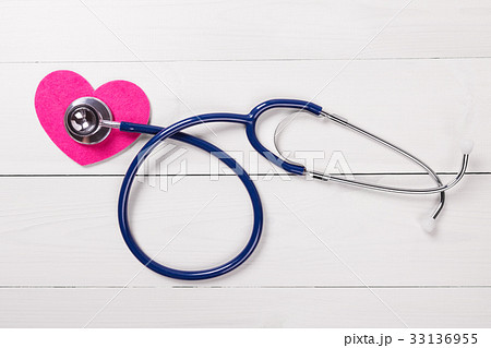Stethoscope on heart shape over wooden background Stethoscope on heart shape over wooden background 33136955