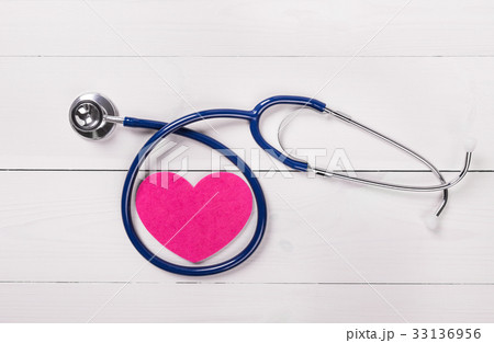 Stethoscope on heart shape over wooden background Stethoscope on heart shape over wooden background 33136956