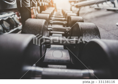 Iron dumbbells locating in row on shelves 33138116