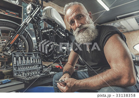 Cheerful old man ready for motorbike renovation 33138358