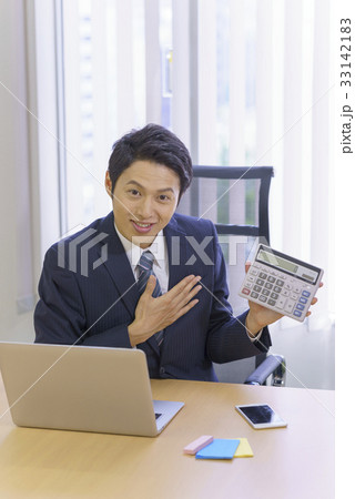 お任せください！計算機を片手に見積契約金額を提示提案説明するスーツ姿の爽やかな若いビジネスマン 33142183