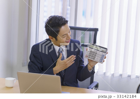 お任せください！計算機を片手に見積契約金額を提示提案説明するスーツ姿の爽やかな若いビジネスマン 33142184