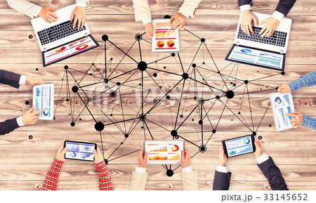 Top view of businesspeople sitting at table and using gadgets Top view of businesspeople sitting at table and using gadgets 33145652