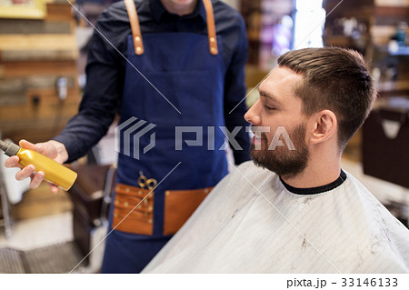 barber showing hair styling spray to male customer barber showing hair styling spray to male customer 33146133