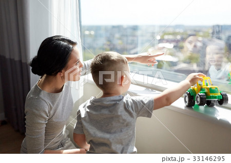 mother and son looking through window at home mother and son looking through window at home 33146295