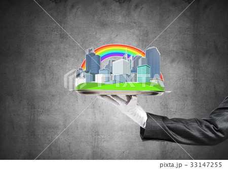 Hand holding metal tray with modern city model against concrete background 33147255