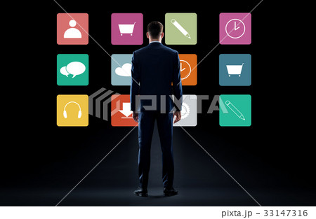 businessman in suit looking at virtual menu icons businessman in suit looking at virtual menu icons 33147316