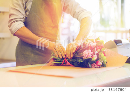 florist wrapping flowers in paper at flower shop 33147604