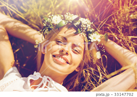 happy woman in wreath of flowers lying on straw happy woman in wreath of flowers lying on straw 33147702