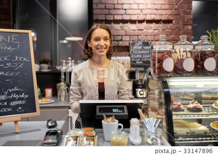 happy woman or barmaid with cashbox at cafe 33147896
