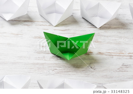 Business leadership concept with white and color paper boats on wooden table 33148325