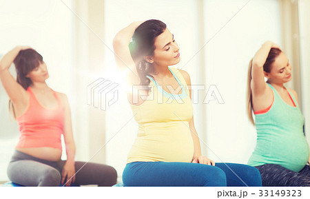 happy pregnant women exercising on fitball in gym 33149323
