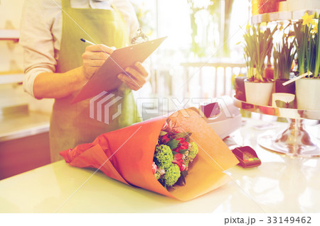 close up of man with clipboard at flower shop 33149462