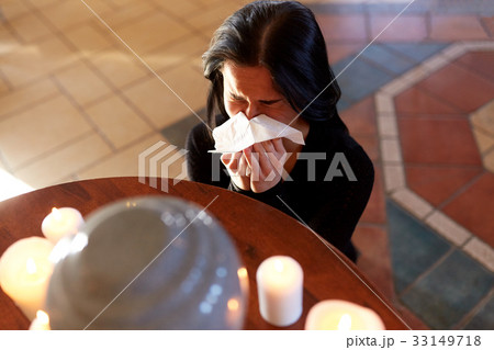woman with cremation urn crying in church 33149718