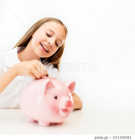 happy smiling girl putting coin into piggy bank 33150091