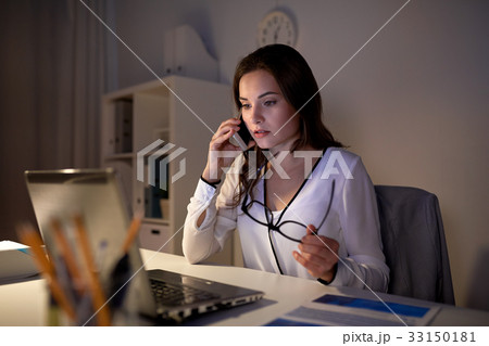 woman with laptop calling on smartphone at office woman with laptop calling on smartphone at office 33150181