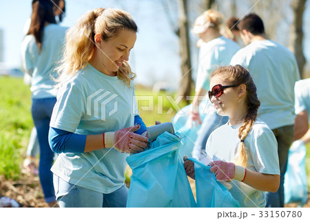volunteers with garbage bags cleaning park area volunteers with garbage bags cleaning park area 33150780