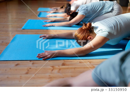 group of people doing yoga hare pose at studio 33150950