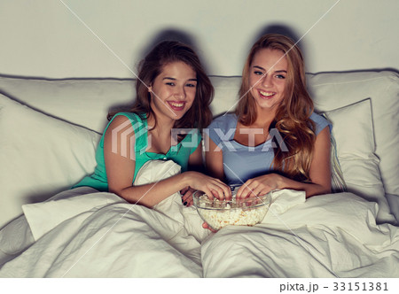 happy friends with popcorn and watching tv at home happy friends with popcorn and watching tv at home 33151381