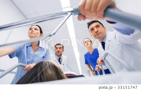 medics with woman on hospital gurney at emergency 33151747