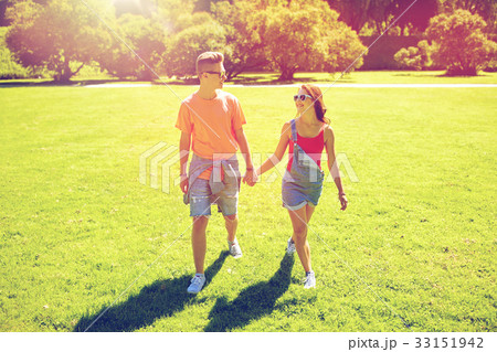 happy teenage couple walking at summer park 33151942
