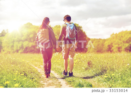 happy couple with backpacks hiking outdoors 33153014