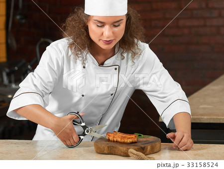 Professional chef cutting chicken steak with 33158524