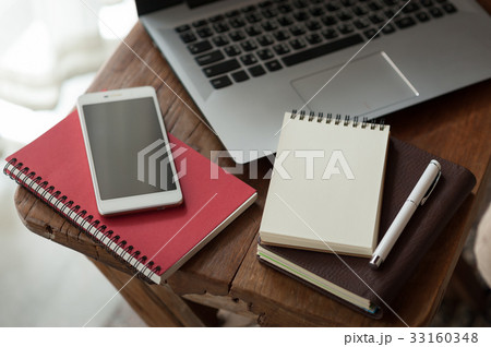 Notebook and laptop computer on wood table 33160348