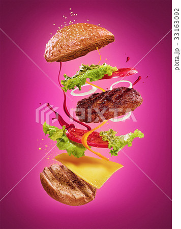 The hamburger with flying ingredients on lilac 33163092