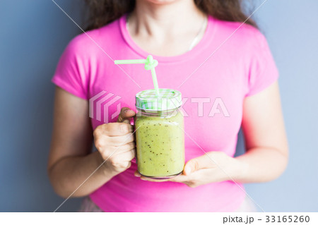 Healthy green smoothie in woman's hand. Vegan, raw 33165260