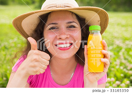Young woman holding a bottle with juice and Young woman holding a bottle with juice and 33165350