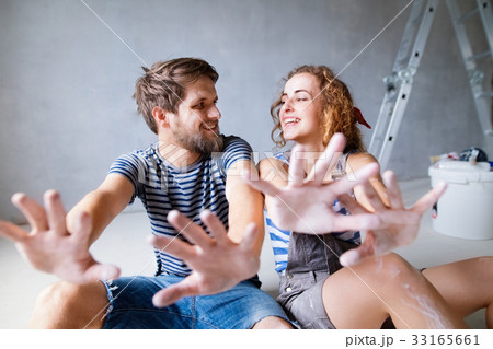 Young couple painting walls in their new house. Young couple painting walls in their new house. 33165661