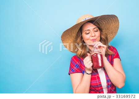 Young sexy woman drinking tasty smoothie on blue Young sexy woman drinking tasty smoothie on blue 33169572