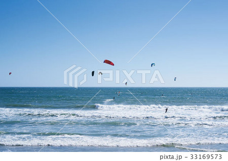 Remote view at kite surfers riding the waves 33169573