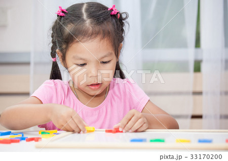 child girl play and learn magnetic alphabets 33170200