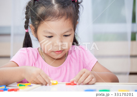 child girl play and learn magnetic alphabets 33170201