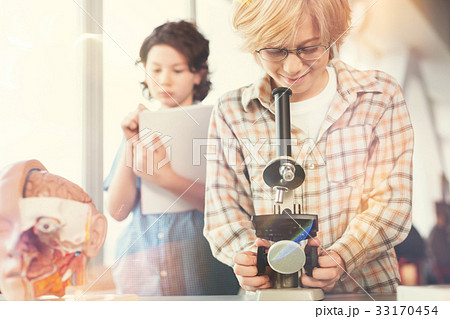 Positive delighted blonde boy looking into 33170454