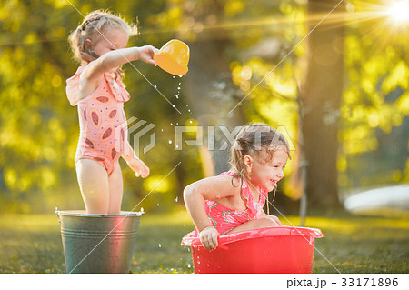 The cute little blond girls playing with water 33171896