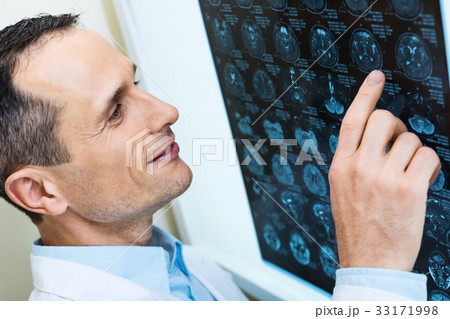 Handsome doctor comparing computer tomography Handsome doctor comparing computer tomography 33171998