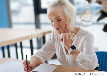 Happy aged woman writing down her memories 33172605