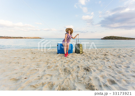 Happy traveler woman with suitcase on the beach Happy traveler woman with suitcase on the beach 33173921